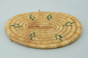 Image of oval coiled grass mat with green decoration